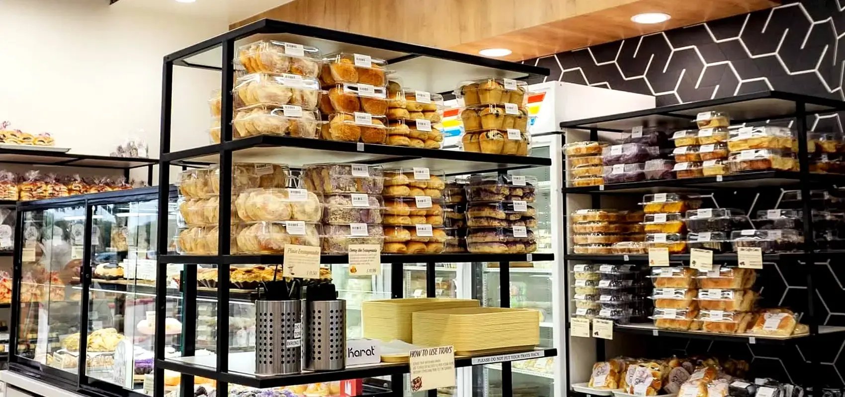 Shelves of freshly packaged pastries and baked goods inside a bakery