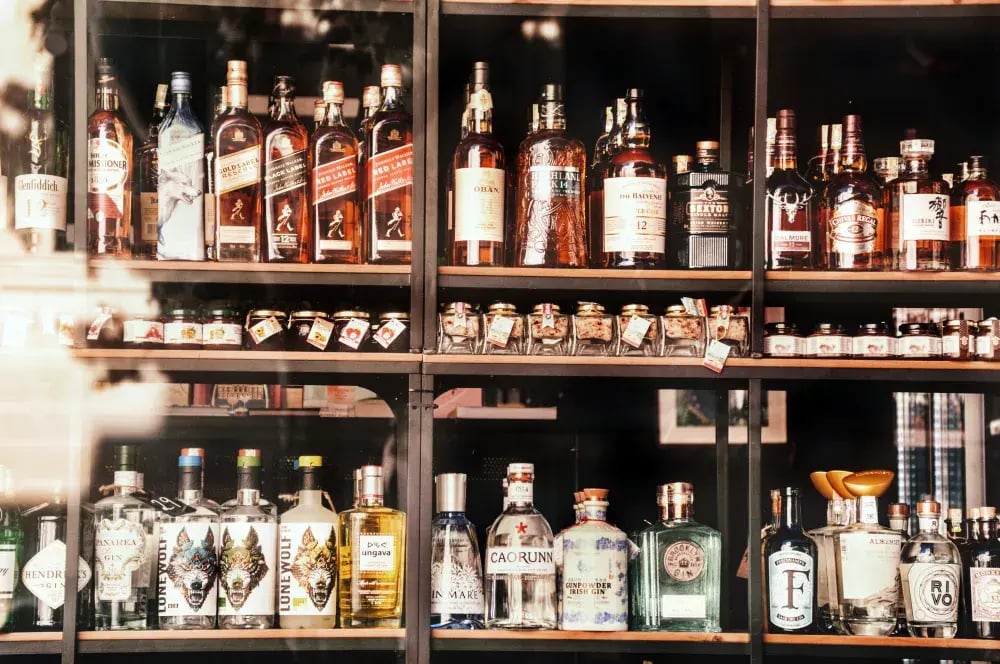Shelves of bottled spirits behind a store window