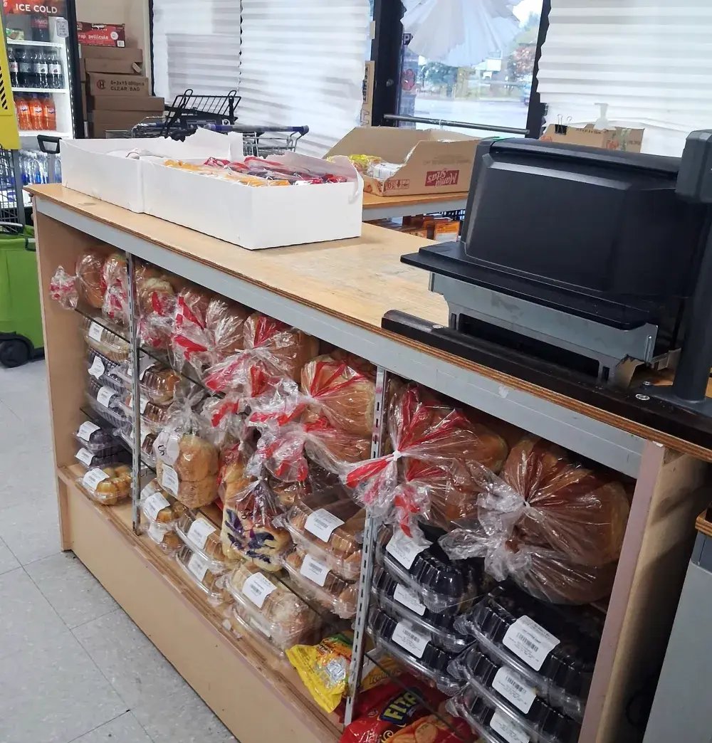 Bakery counter with packaged breads and pastries next to the register